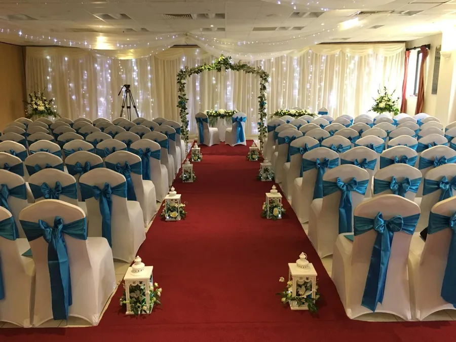 Ceremony rows of white stretch chair covers with turquoise taffeta bows